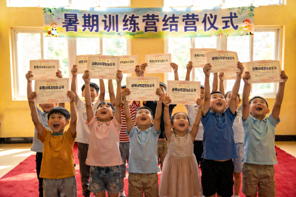 暑期训练营结营仪式上，孩子们高举结业证书合影，笑容自豪