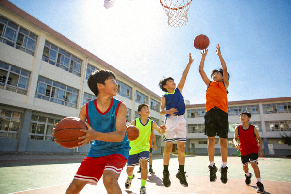 青少年在学校体育课上积极参与篮球训练，展现青春活力