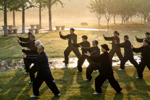 清晨公园里一群中老年人正在专业教练指导下练习太极拳