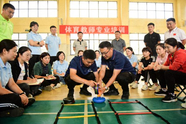 体育教师专业培训现场，教师们正在学习新的教学方法和运动技能