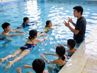 学校游泳课程教学现场，学生在教练指导下学习游泳技巧