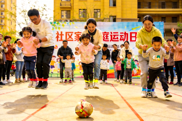 社区家庭运动日活动现场，亲子家庭参与趣味运动比赛