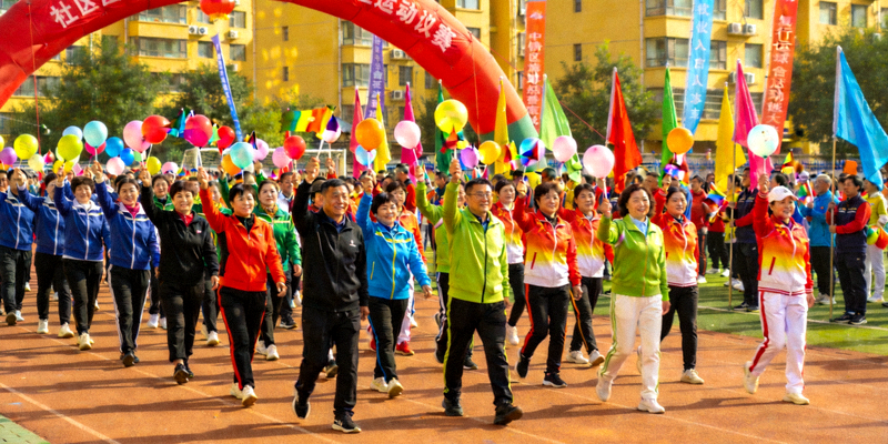 阳光社区运动会开幕式现场，居民们热情参与，彩旗飘扬