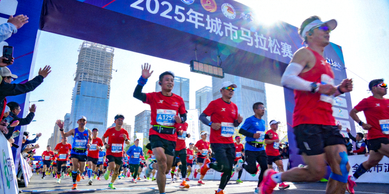 2025年城市马拉松赛全民健身跑者穿过城市地标，充满活力与激情